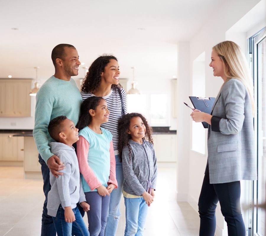 Realtor speaking to a family of five in a house viewing